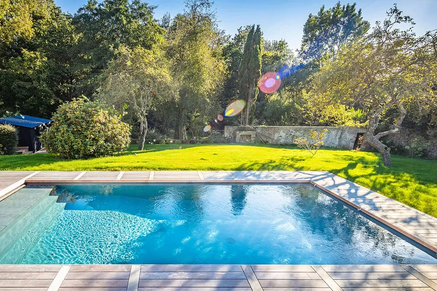 Pool mit Holzrand im Garten, alte Bäume und Rasen